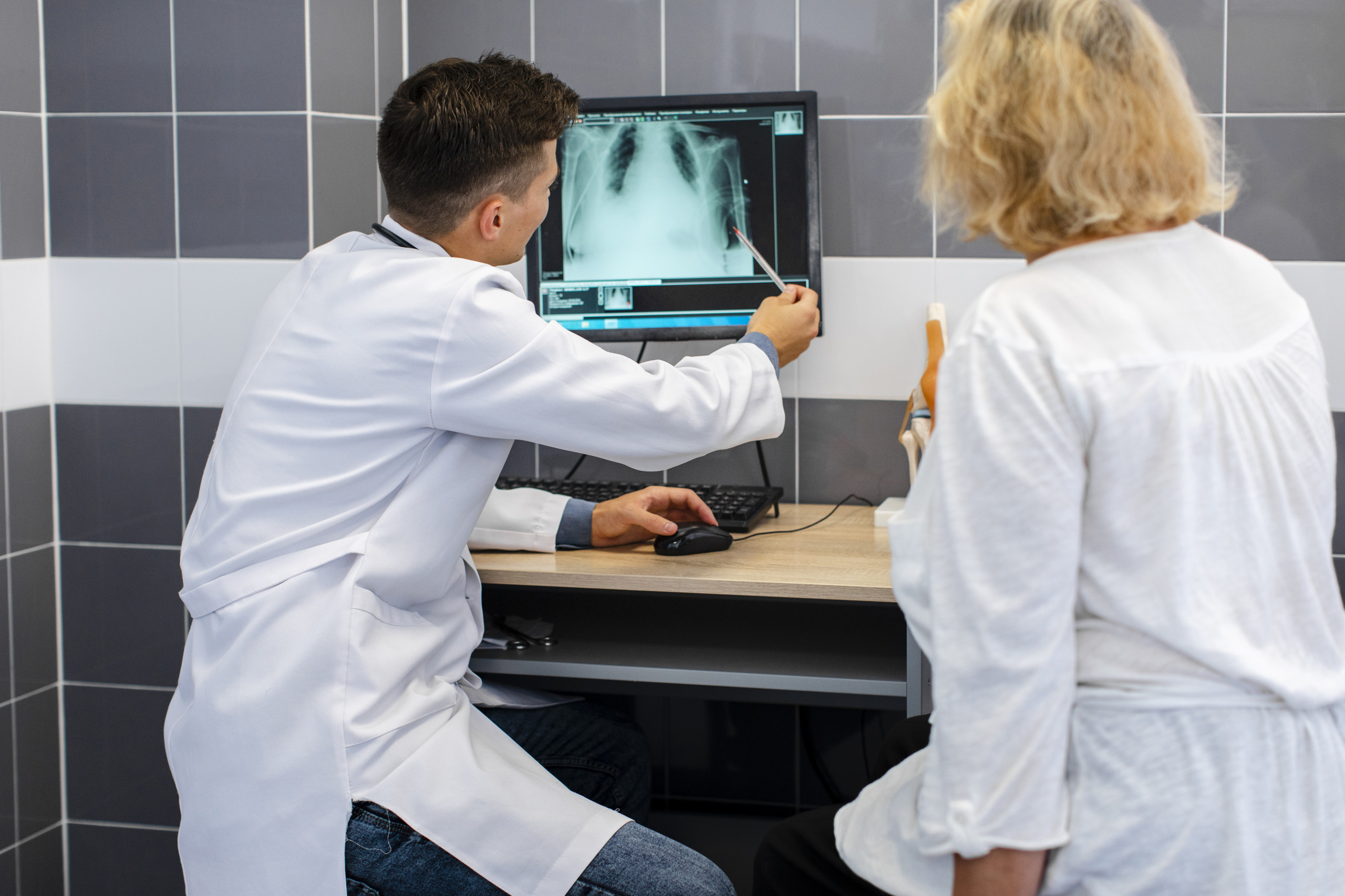 Radiologieinformationssystem (RIS) in der Praxis – Digitale Befundung und Dokumentation Radiologe bespricht ein digitales Röntgenbild, dokumentiert im Radiologieinformationssystem (RIS)